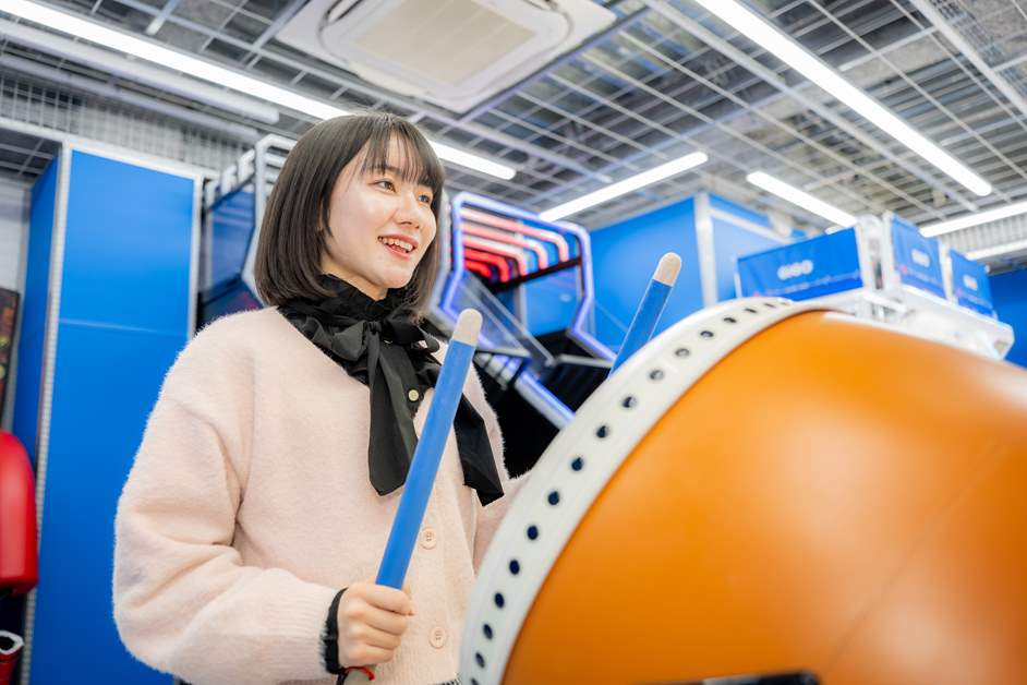 「太鼓の達人」でリズムよくバチを振るう村上さん
